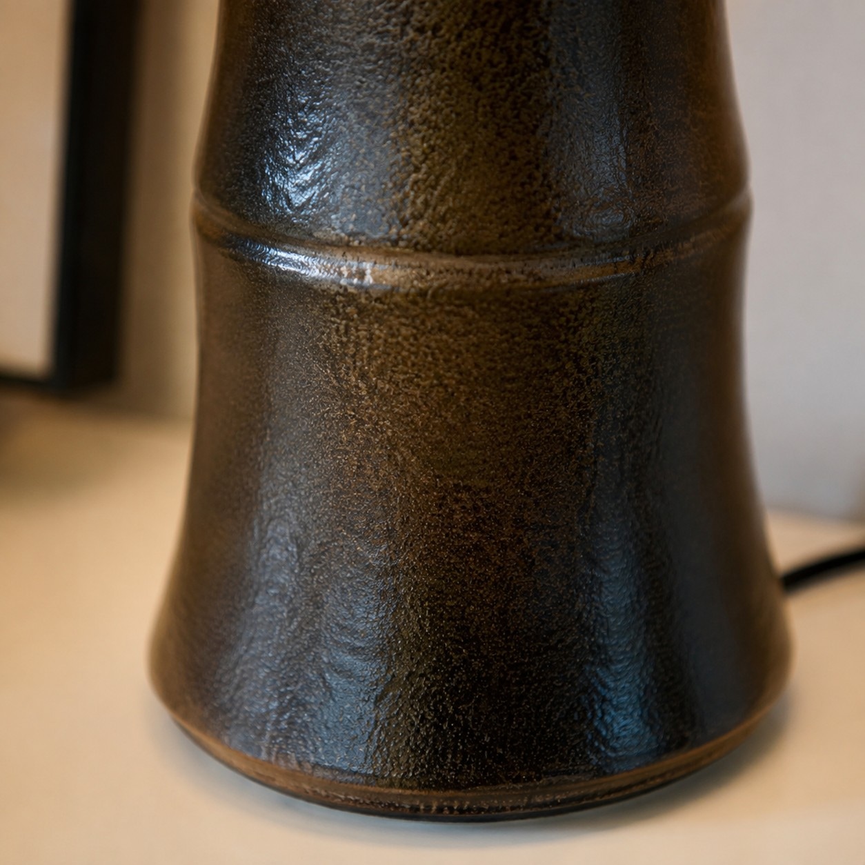 Close view of dark glazed ceramic lamp body